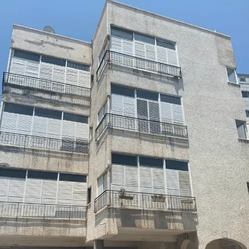 בניין מגורים לפני עבודות האיטום והחידוש בסנפלינג — פרויקט 2 של הרמטיקו: קירות חיצוניים מוכתמים וסדוקים